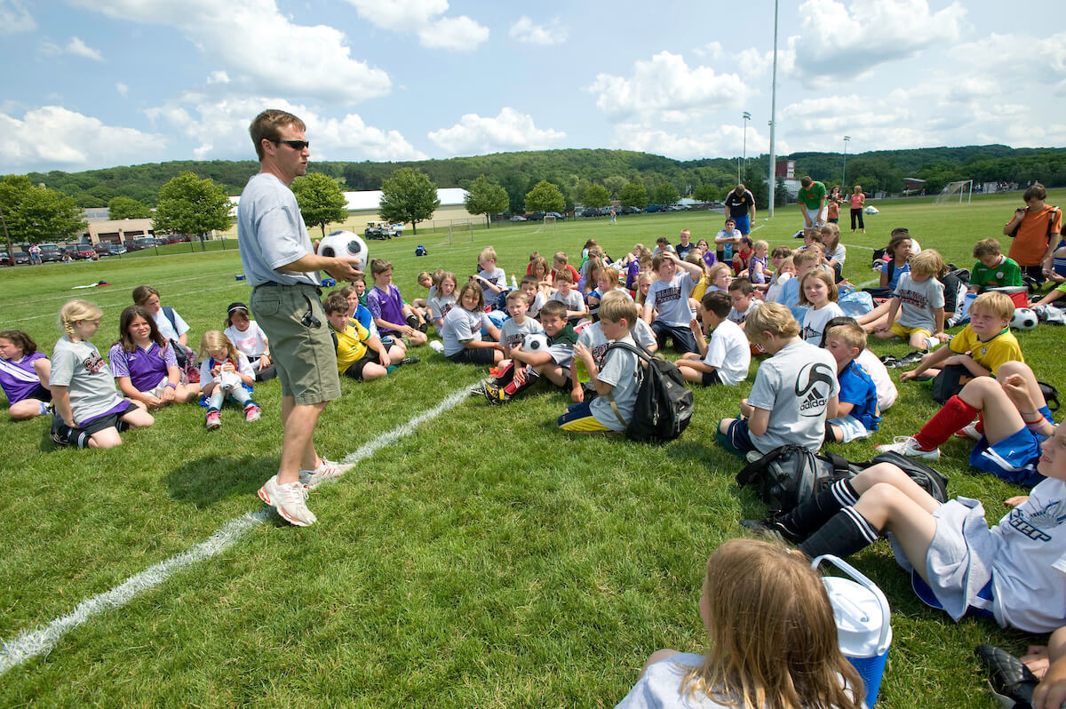 Ƶ’s head soccer coach speaks to participants of a youth soccer camp on the university’s campus.